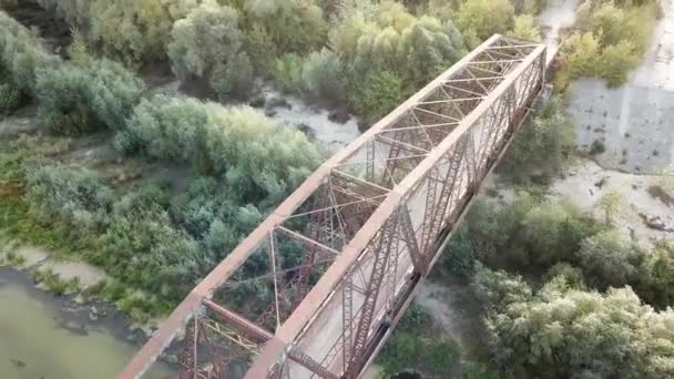 Luchtfoto van oude roestige ijzeren spoorbrug over de rivier.. — Stockvideo