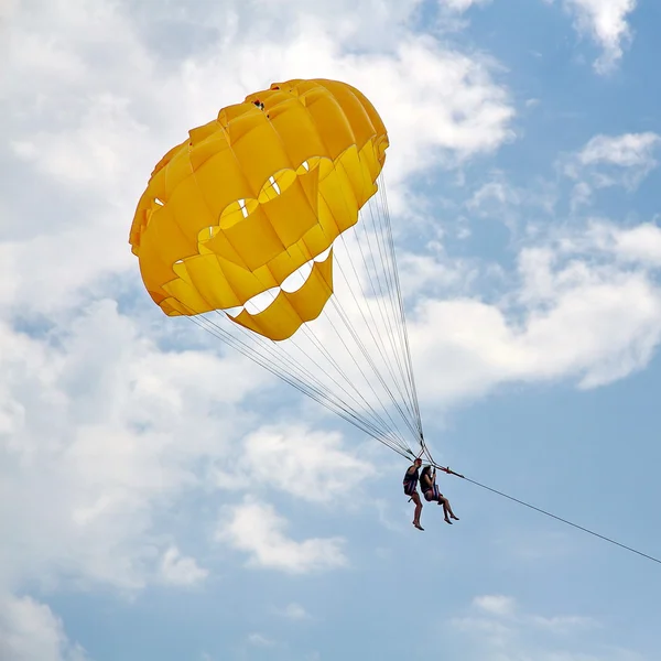 Parachutisme dans un ciel bleu près de la plage de la mer — Photo