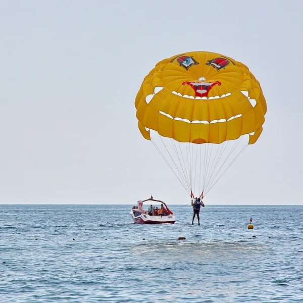 Parasailing v modré obloze blízko pláže Stock Snímky