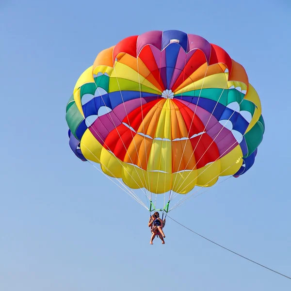 Parachutisme dans un ciel bleu près de la plage de la mer — Photo