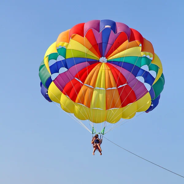 Parachutisme dans un ciel bleu près de la plage de la mer — Photo