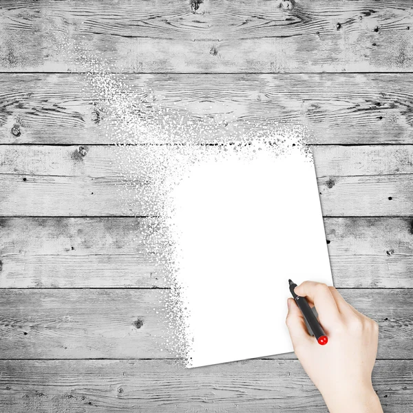 Vrouwelijke hand schrijven op papier op hout achtergrond — Stockfoto