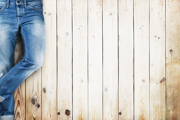 Calça jeans sobre pranchas de madeira branca fundo — Fotografia de Stock