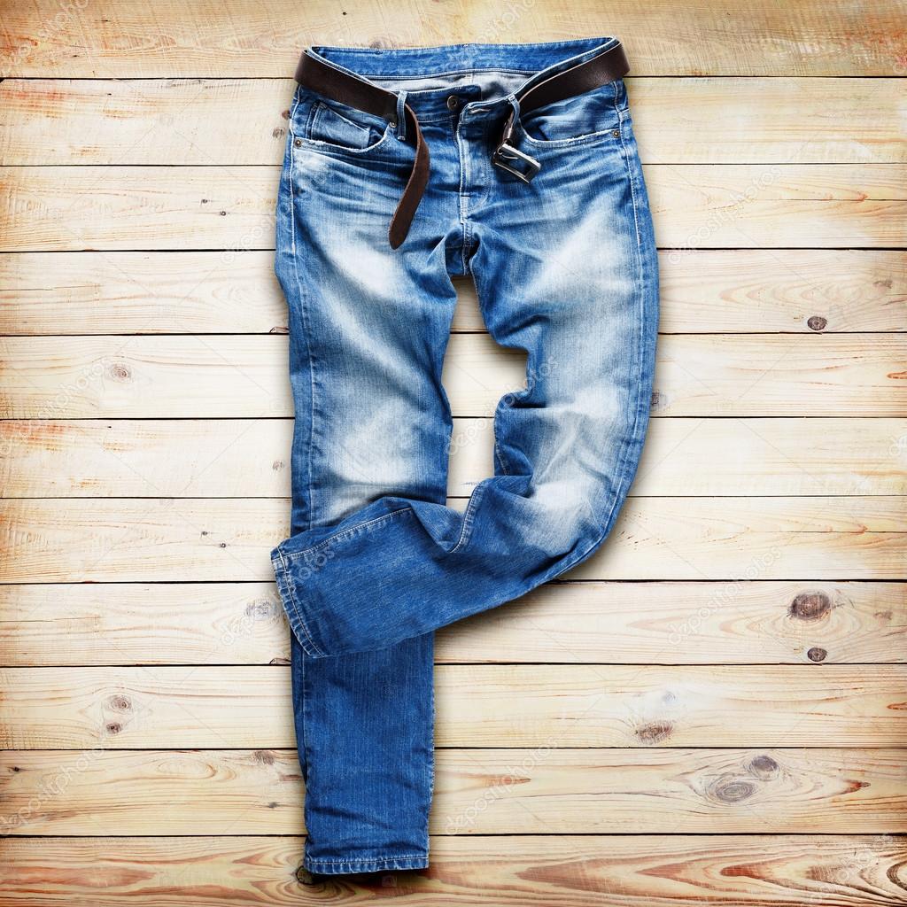 Blue jeans trouser with leather belt over white wood planks background ...