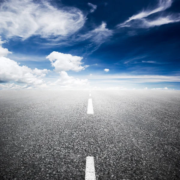 Asphalted highway over blue sky with white clouds background — Stock Photo, Image