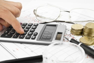 Hesap makinesi, para, gözlük ve kalem
