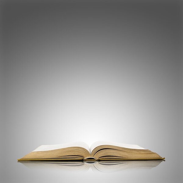 Old open book isolated on grey background