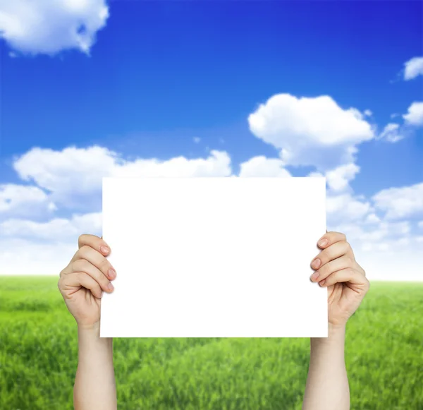 Paper in hand and green field — Stock Photo, Image