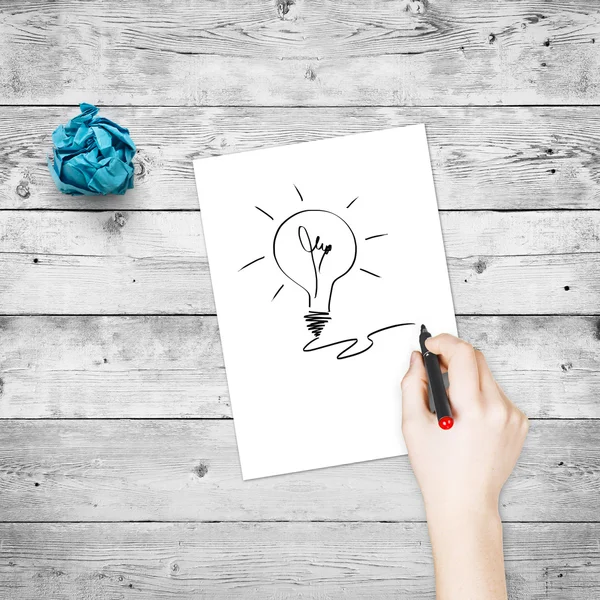 Female hand drawing light bulb — Stock Photo, Image