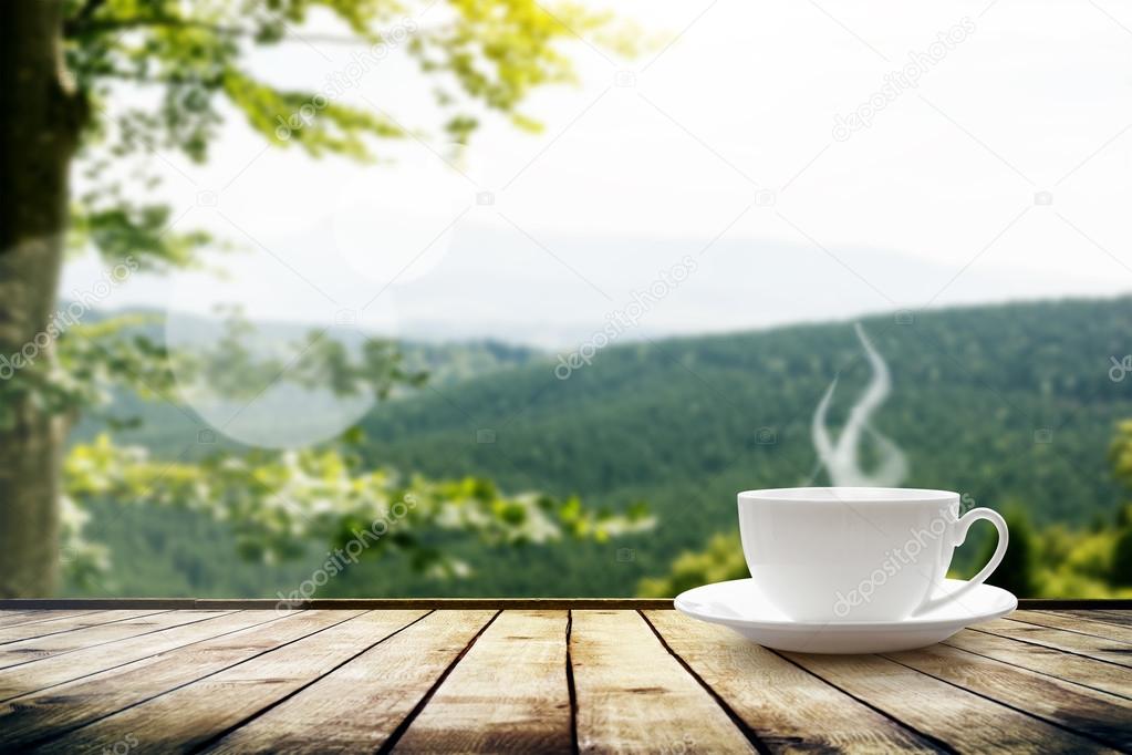 Cup with tea over mountains landscape