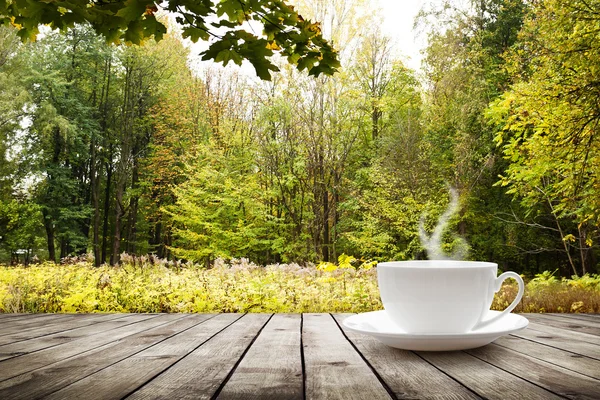 Copo com bebida quente na mesa de madeira — Fotografia de Stock