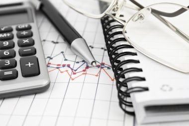 Defter, gözlük, kalem ve hesap makinesi