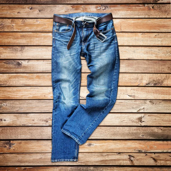 Jeans azuis sobre fundo de madeira — Fotografia de Stock