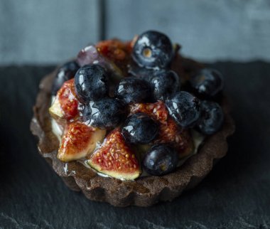 Siyah bir yüzeye yakın çekimde taze incirli kurabiye.