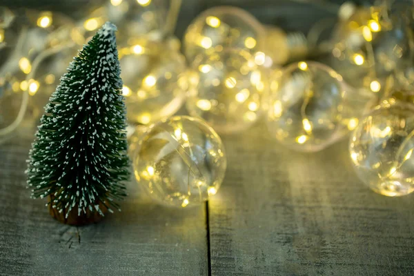 Árbol Navidad Decorativo Iluminado Por Una Guirnalda Una Superficie Madera — Foto de Stock