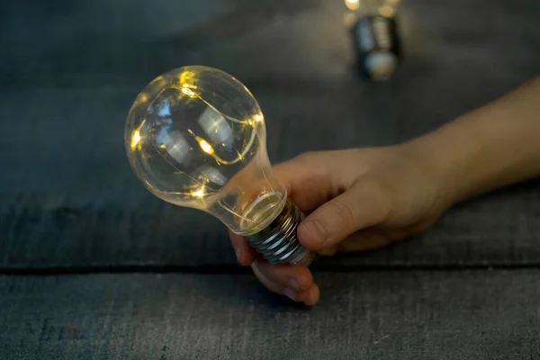 Barnens Hand Med Dekorativ Glödlampa Ljus Träyta Nära Håll — Stockfoto