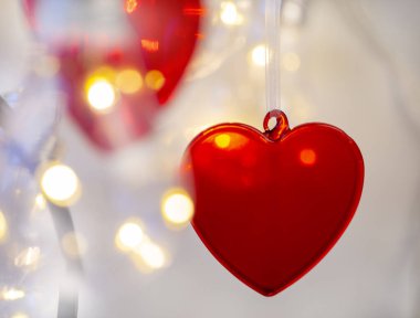Arka planda kırmızı kalp, aşkın sembolü.