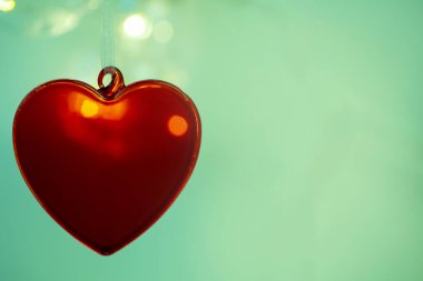 Arka planda kırmızı kalp, aşkın sembolü.