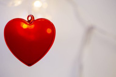 Arka planda kırmızı kalp, aşkın sembolü.