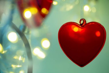 Arka planda kırmızı kalp, aşkın sembolü.
