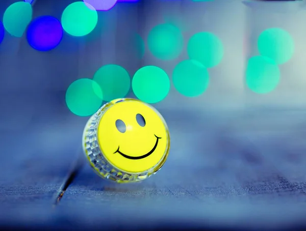 yellow smile, yo yo toy with bright bokeh on a dark background, concept photo