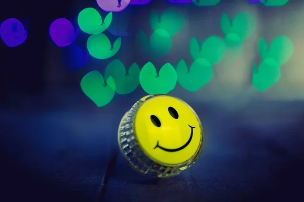 yellow smile, yo yo toy with bright bokeh on a dark background, concept photo