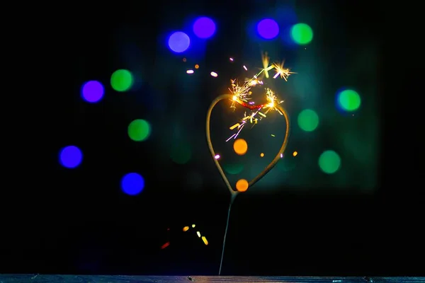 Sparkler Form Burning Heart Surrounded Colorful Bokeh Close — Stock Photo, Image