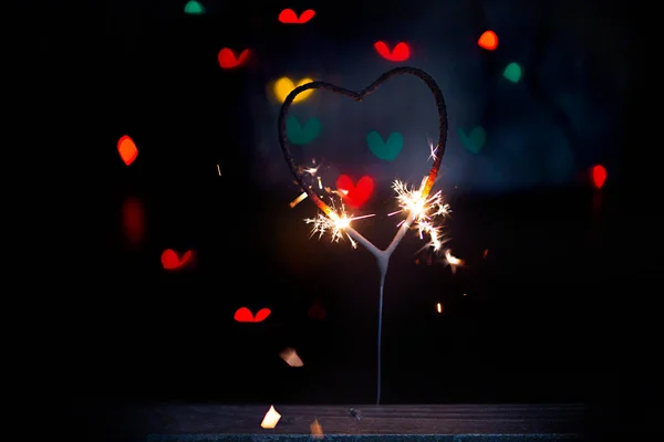 Sparkler Form Burning Heart Surrounded Colorful Bokeh Close — Stock Photo, Image