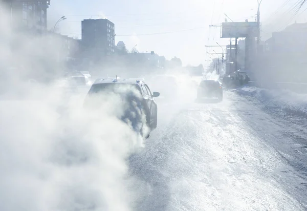 pollution from the exhaust of cars in the city in the winter. Smoke from cars on a cold winter day