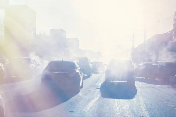 air pollution from the exhaust of cars in the city during the cold day, environmental pollution in the city