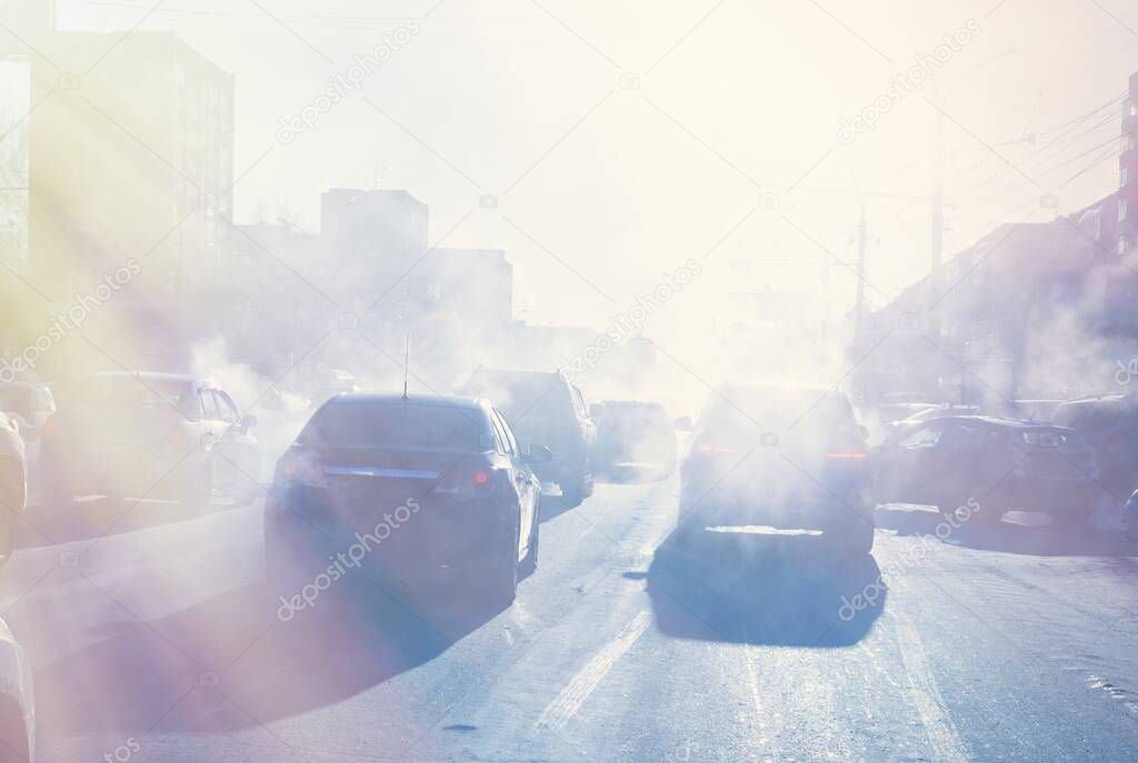 air pollution from the exhaust of cars in the city during the cold day, environmental pollution in the city