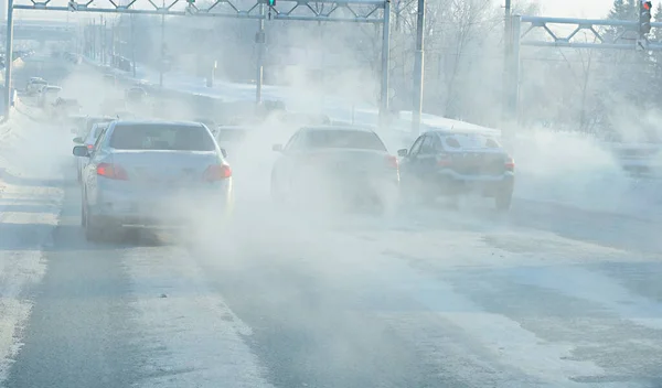 air pollution from exhaust fumes from cars in the city, on a cold day, air pollution in cities