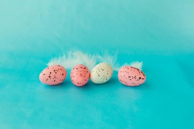 Mavi düz bir yüzeyde parlak paskalya yumurtaları, Paskalya dekoru, yakın plan.