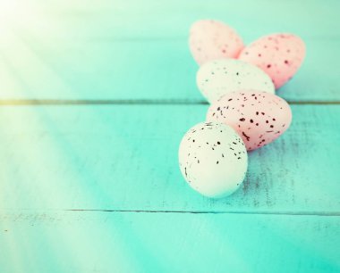 Mavi düz bir yüzeyde parlak paskalya yumurtaları, Paskalya dekoru, yakın plan.