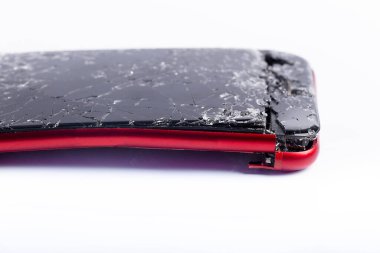 Beyaz arka planda bozuk telefon, yakın planda kırılmış elektronik alet.