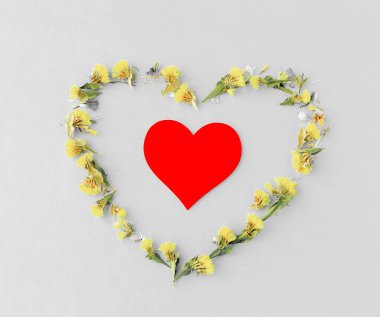 Mavi tek renkli arka planda sarı kurumuş çiçeklerin kalbi, aşkın sembolü, minimalizmin