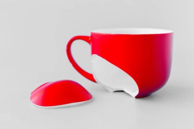 Kırık kırmızı bardak mavi arka planda, boşanma sembolü, kayıp, yakın plan