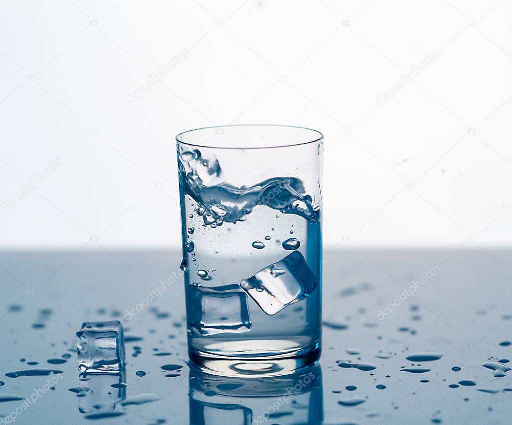 clear water spray in a glass with ice, clear water in a glass with spray close-up