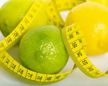 Masanın beyaz yüzeyinde limon ve yakın çekim için mezura var.