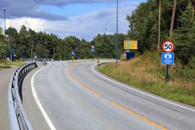 Road and roundabout in Vestland region, Norway. 50 kmh speed limit and speed camera warning.