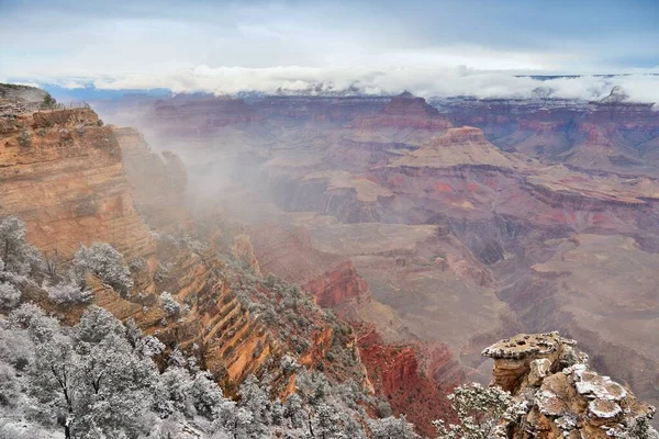 Grand Canyon misty weather landscape in Arizona, United States. Mather point view with snow.