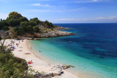 CORFU, GREECE - 31 Mayıs 2016: İnsanlar Kassiopi, Korfu Adası 'ndaki plajın tadını çıkarıyor. 2012 yılında Korfu 'yu 558 bin turist ziyaret etti.