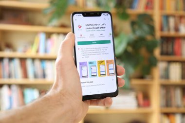 WARsaw, POLAND - 29 Ocak 2021: Android OS, Xiaomi markalı akıllı telefona Covid Alarm Kanada uygulaması yükleyen kullanıcı. Kanada 'daki resmi hükümet koronavirüs pandemik yönetim uygulaması..