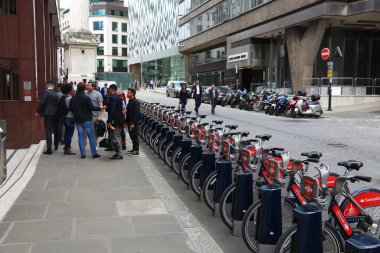 LONDON, İngiltere - 8 Temmuz 2016: Londra, İngiltere 'de insanlar Santander Cycles bisiklet kiralama istasyonundan geçiyor. Halka açık bisiklet kiralama ağının 839 istasyonu ve 13.600 bisikleti vardır..