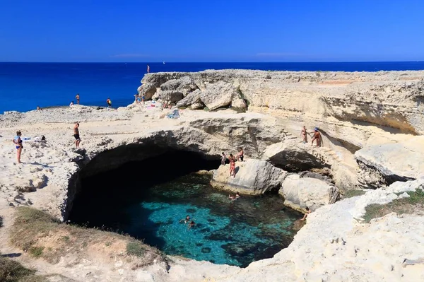 SALENTO, İtalya - 1 Haziran 2017 İnsanlar İtalya 'nın Salento Yarımadası, Roca' daki Grotta Della Poesia yüzme mağarasını ziyaret ediyor. Yıllık 50 milyon ziyaretçiyle İtalya, en çok ziyaret edilen ülkelerden biri oldu..