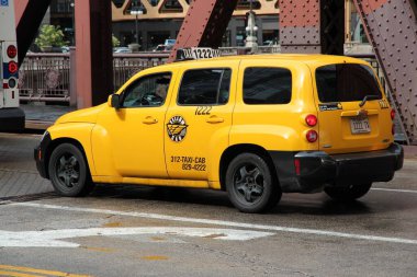 CHICAGO, USA - JUNE 26, 2013: Chevrolet HHR yellow taxi cab in central Chicago. Chicago is the 3rd most populous US city. clipart