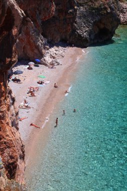 KONAVLE, CROATIA - 28 Haziran 2019: İnsanlar Hırvatistan 'ın Dalmaçya bölgesindeki Konavle bölgesindeki kayalıkların altındaki Pasjaca plajında tatil yapıyorlar.