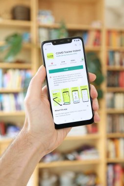 WARsaw, POLAND - 29 Ocak 2021: Android OS, Xiaomi markalı akıllı telefona Covid Tracker Ireland uygulaması yükleyen kullanıcı. İrlanda 'daki resmi hükümet koronavirüs pandemik yönetim uygulaması..