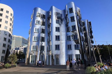 DÜKSELDORF, GERMANY - 19 Eylül 2020: İnsanlar Düsseldorf, Almanya 'daki Neuer Zollhof modern mimarisini ziyaret ediyor. Konut kompleksi Amerikalı mimar Frank Gehry tarafından 1998 yılında tasarlanmıştır..