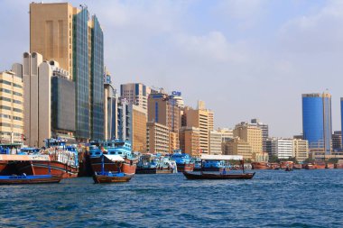 DUBAI, BAE - 9 Aralık 2017: Dhow ahşap kargo gemileri BAE 'deki Dubai Creek limanına demirlediler. Dubai, BAE 'nin en kalabalık şehri ve büyük bir küresel şehirdir..
